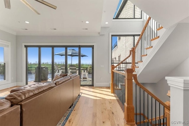 living room featuring light wood finished floors, baseboards, crown molding, and recessed lighting