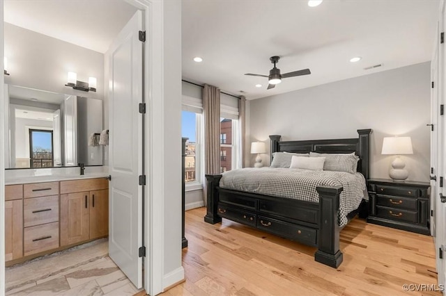 bedroom with light wood-style flooring, recessed lighting, a sink, visible vents, and baseboards