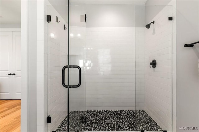 full bath with wood finished floors and a shower stall