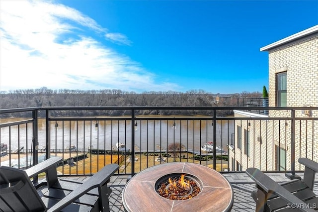 balcony featuring a water view and a fire pit