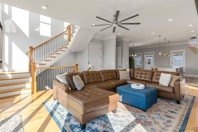 living area with baseboards, stairway, crown molding, a chandelier, and recessed lighting