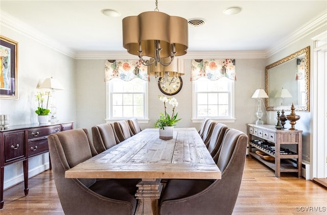 dining room featuring ornamental molding, light hardwood / wood-style floors, a chandelier, and a healthy amount of sunlight