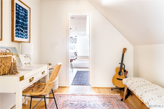 interior space featuring a baseboard radiator, lofted ceiling, and light hardwood / wood-style floors