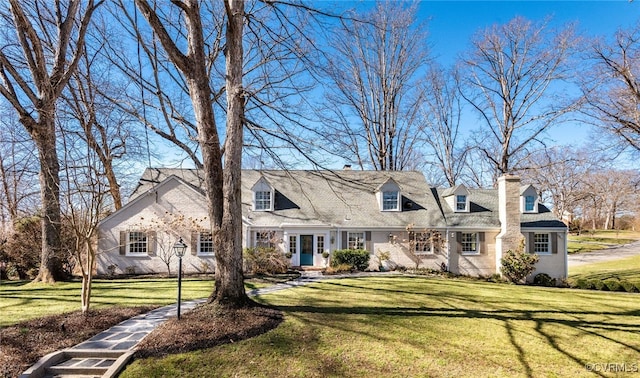 cape cod house featuring a front yard