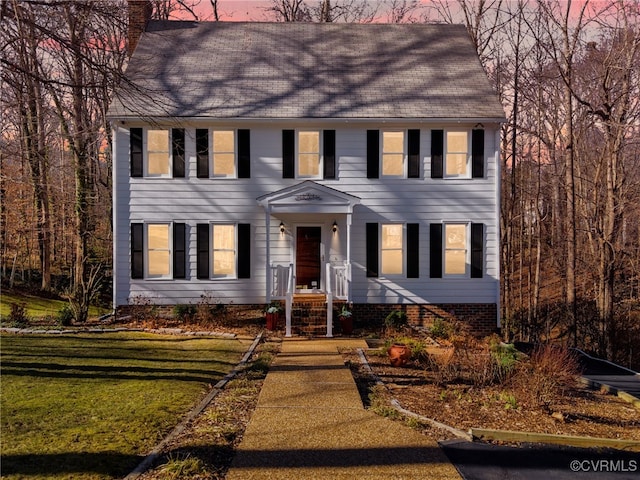 colonial-style house with a front lawn