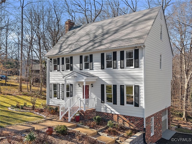 colonial inspired home featuring a front lawn