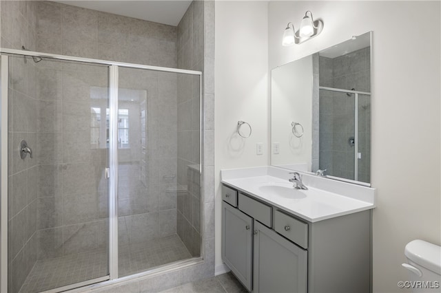 bathroom featuring toilet, vanity, and walk in shower