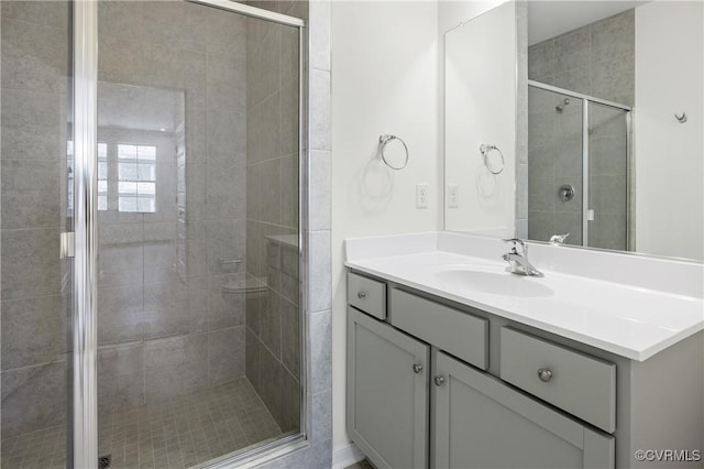 bathroom featuring vanity and a shower with door