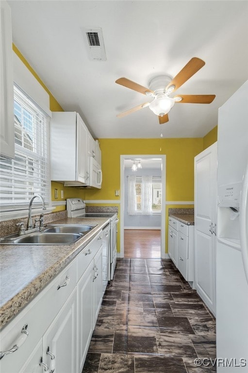 kitchen featuring white appliances, white cabinetry, sink, and plenty of natural light