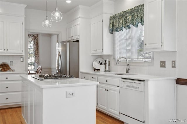 kitchen featuring a center island, light countertops, freestanding refrigerator, white cabinetry, and dishwasher