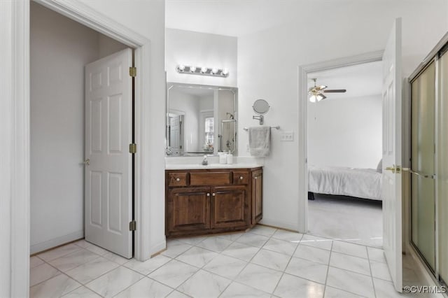 ensuite bathroom featuring a ceiling fan, vanity, baseboards, and ensuite bathroom