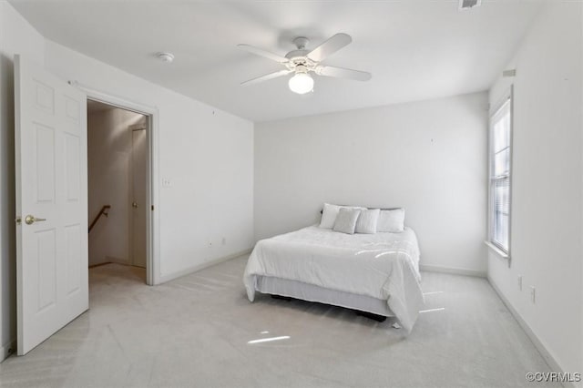 bedroom featuring ceiling fan, baseboards, and light colored carpet