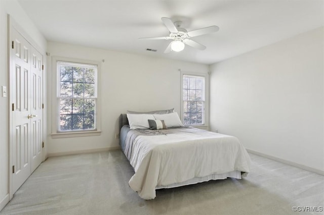 bedroom with visible vents, ceiling fan, light carpet, and baseboards