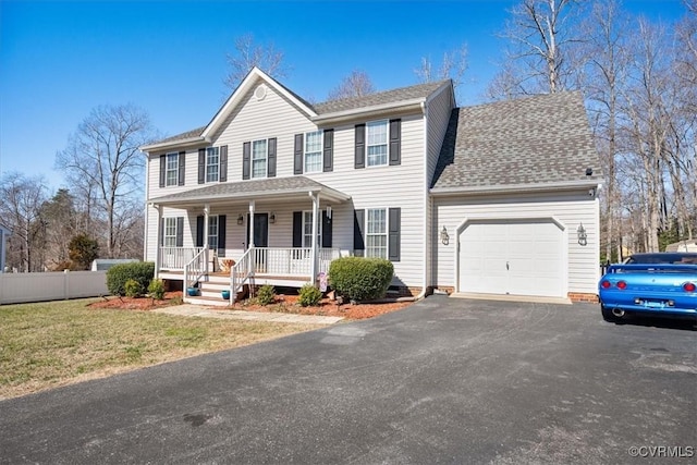 colonial-style house featuring covered porch, a garage, and a front lawn