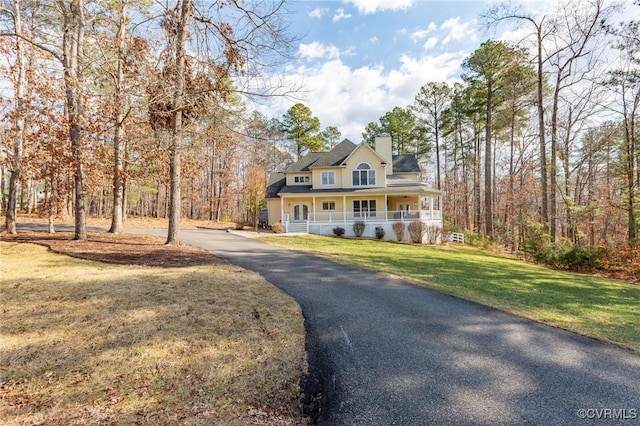 farmhouse-style home with covered porch and a front lawn