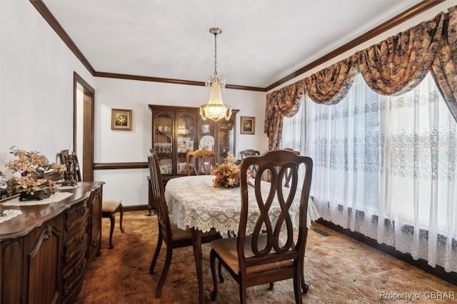 dining room featuring dark carpet, ornamental molding, and a chandelier