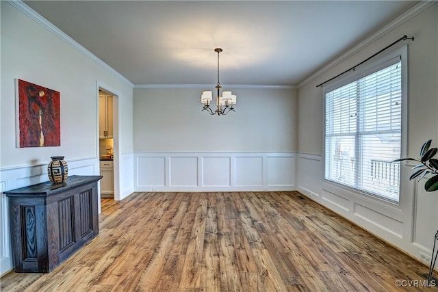 dining area featuring light wood-type flooring, crown molding, and a notable chandelier