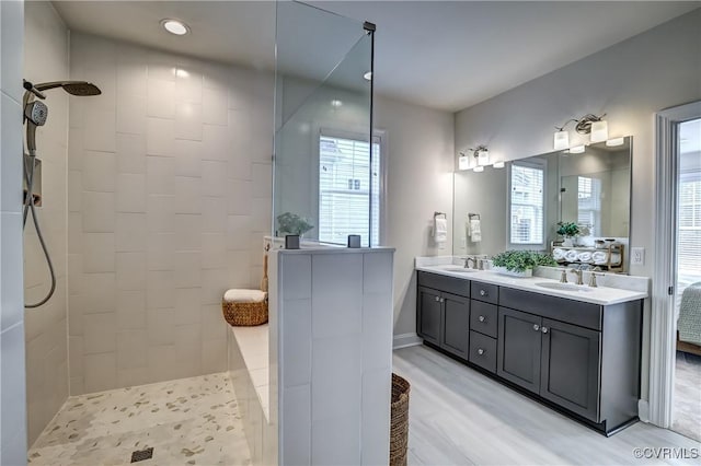 bathroom with vanity, wood-type flooring, and tiled shower