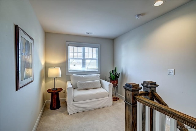 living area featuring light carpet