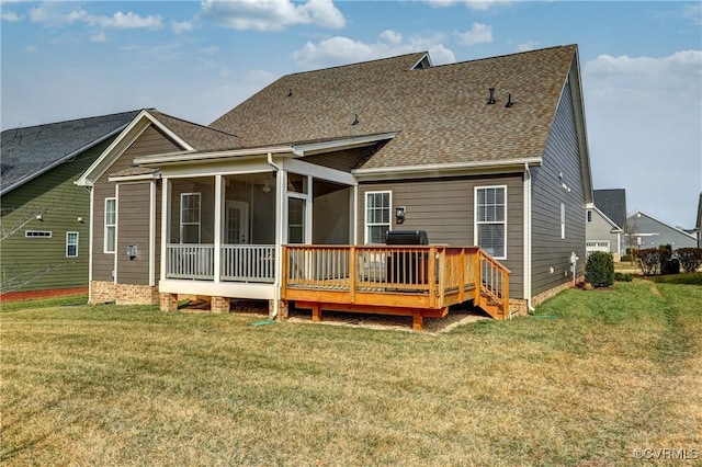 back of property with a yard, a sunroom, and a wooden deck