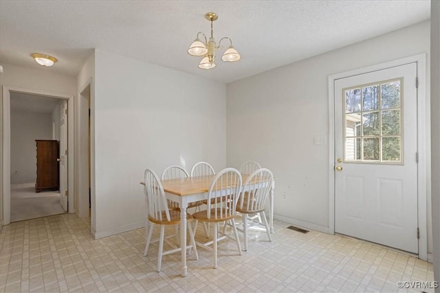 dining room featuring an inviting chandelier and a textured ceiling