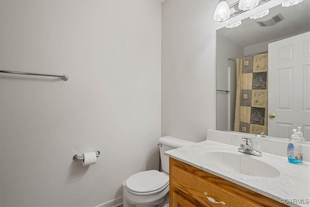 bathroom featuring a notable chandelier, vanity, and toilet