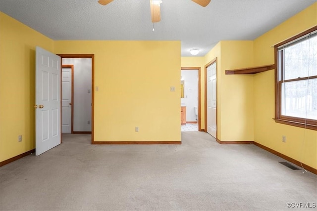 unfurnished room with light carpet, ceiling fan, and a textured ceiling