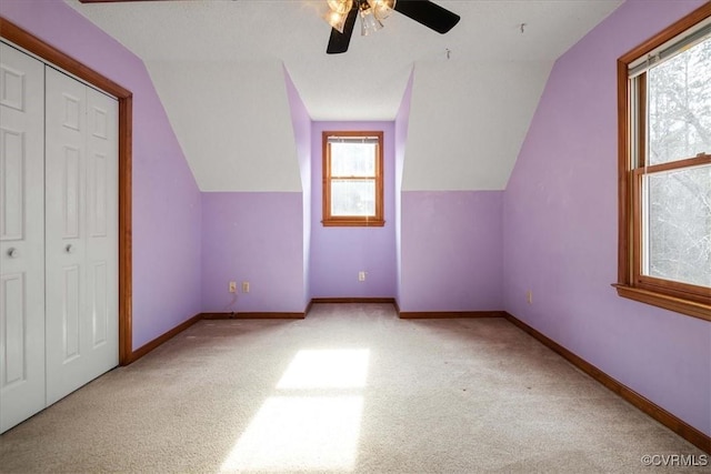 additional living space featuring light carpet, lofted ceiling, and ceiling fan