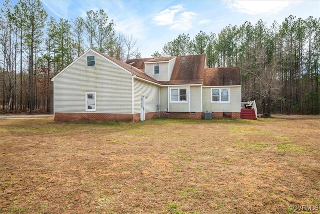 rear view of property with a yard and central air condition unit