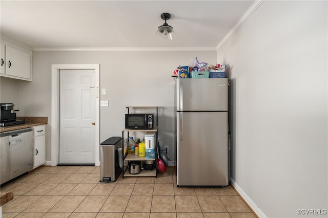 kitchen featuring appliances with stainless steel finishes, light tile patterned flooring, white cabinetry, and crown molding