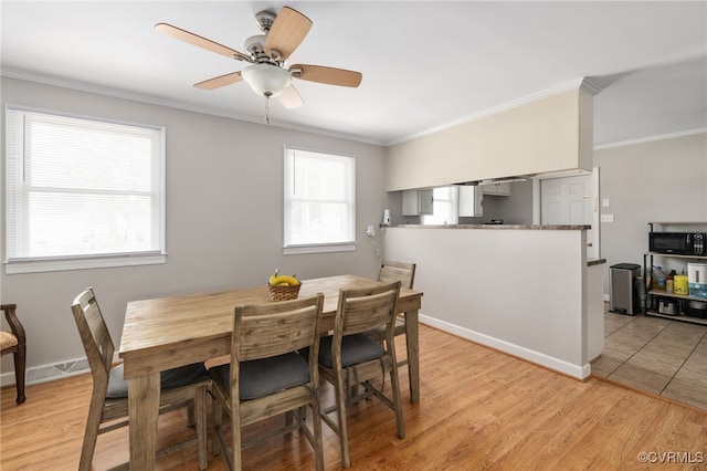 dining room featuring crown molding, ceiling fan, and light hardwood / wood-style flooring