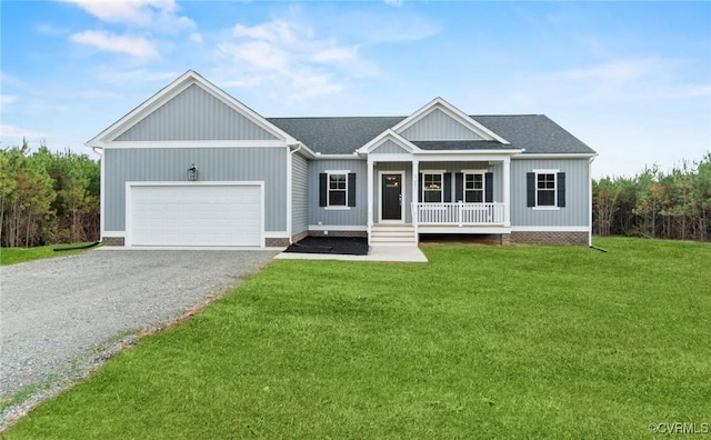 view of front of property featuring covered porch, a front yard, and a garage