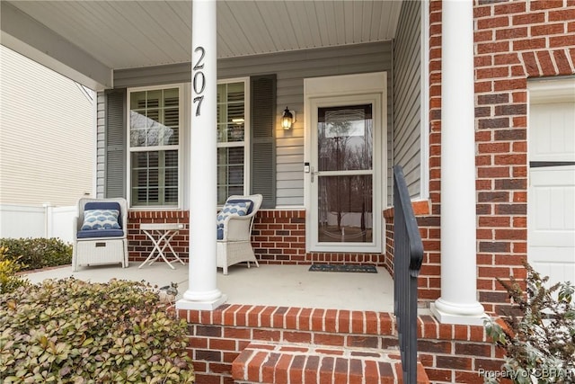 property entrance with covered porch and brick siding