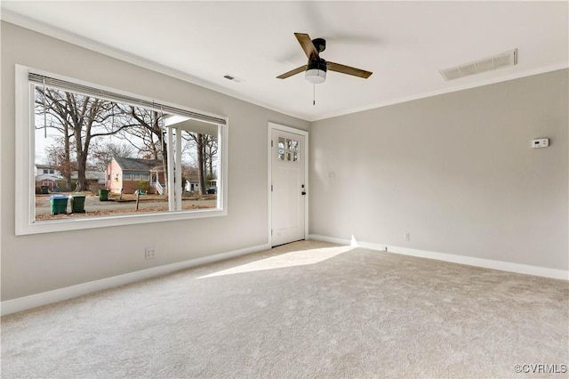 carpeted spare room with ceiling fan and crown molding