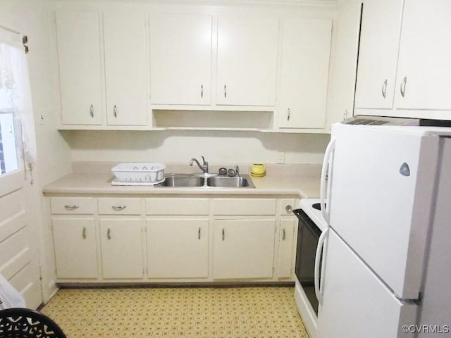 kitchen with sink, white appliances, and white cabinetry