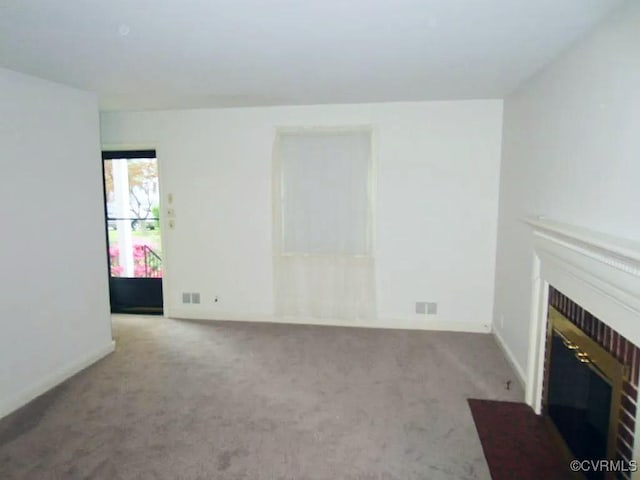 unfurnished living room with light carpet and a brick fireplace