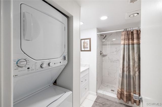 laundry room with laundry area, recessed lighting, light tile patterned floors, and stacked washer and clothes dryer