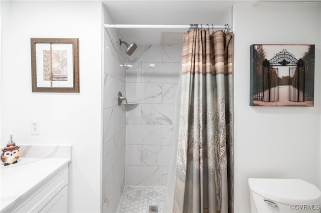 bathroom featuring toilet, a shower stall, and vanity