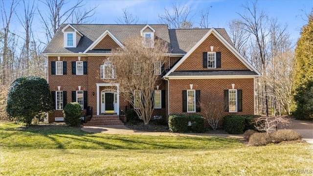 colonial home with brick siding and a front yard