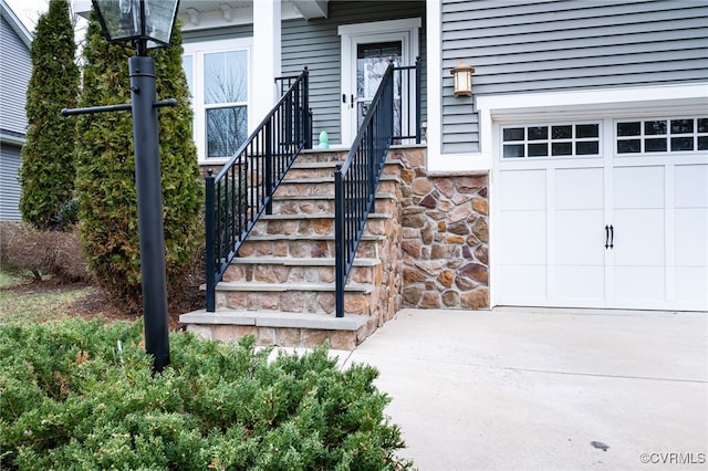 view of exterior entry featuring a garage and stone siding