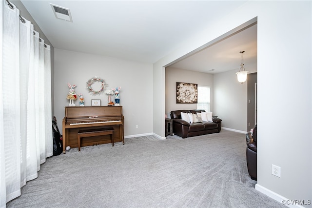 living area featuring baseboards, visible vents, and carpet floors