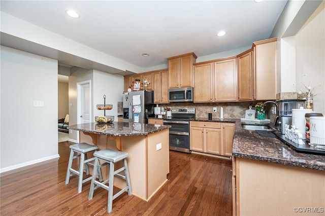 kitchen with tasteful backsplash, a center island, dark wood-style floors, stainless steel appliances, and a sink