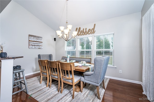 dining space featuring baseboards, a notable chandelier, wood finished floors, and vaulted ceiling