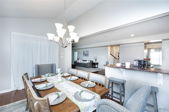 dining area featuring an inviting chandelier, vaulted ceiling, stairs, and wood finished floors