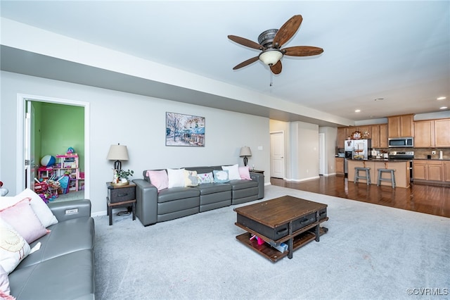 living area featuring recessed lighting, dark colored carpet, baseboards, and ceiling fan