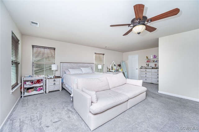 carpeted bedroom with a ceiling fan, baseboards, and visible vents