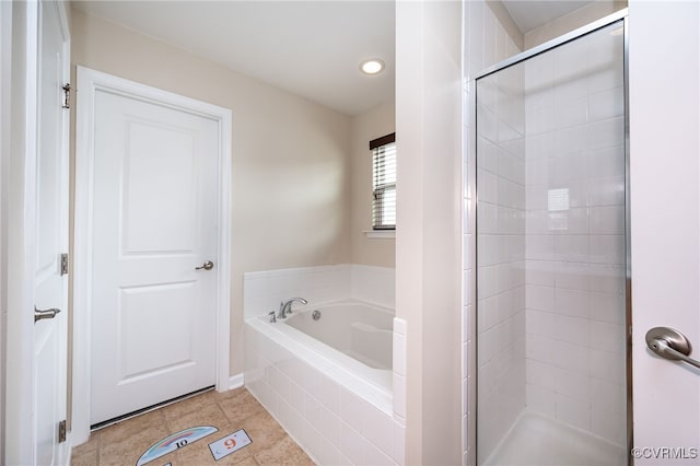 bathroom with tile patterned flooring, a garden tub, and a shower stall