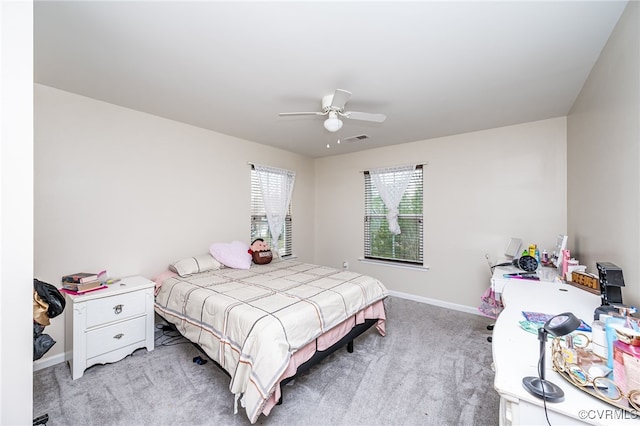 bedroom featuring visible vents, light colored carpet, a ceiling fan, and baseboards