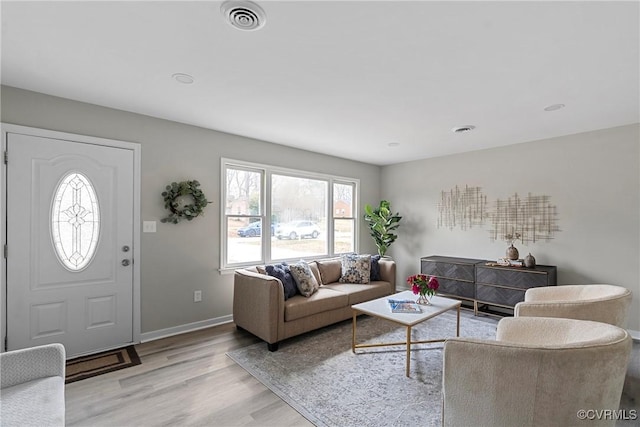 living area featuring visible vents, baseboards, and wood finished floors