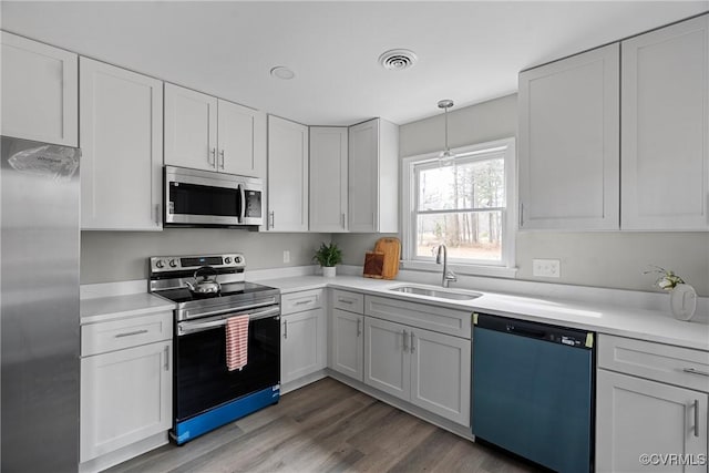 kitchen featuring stainless steel appliances, a sink, visible vents, white cabinets, and light countertops